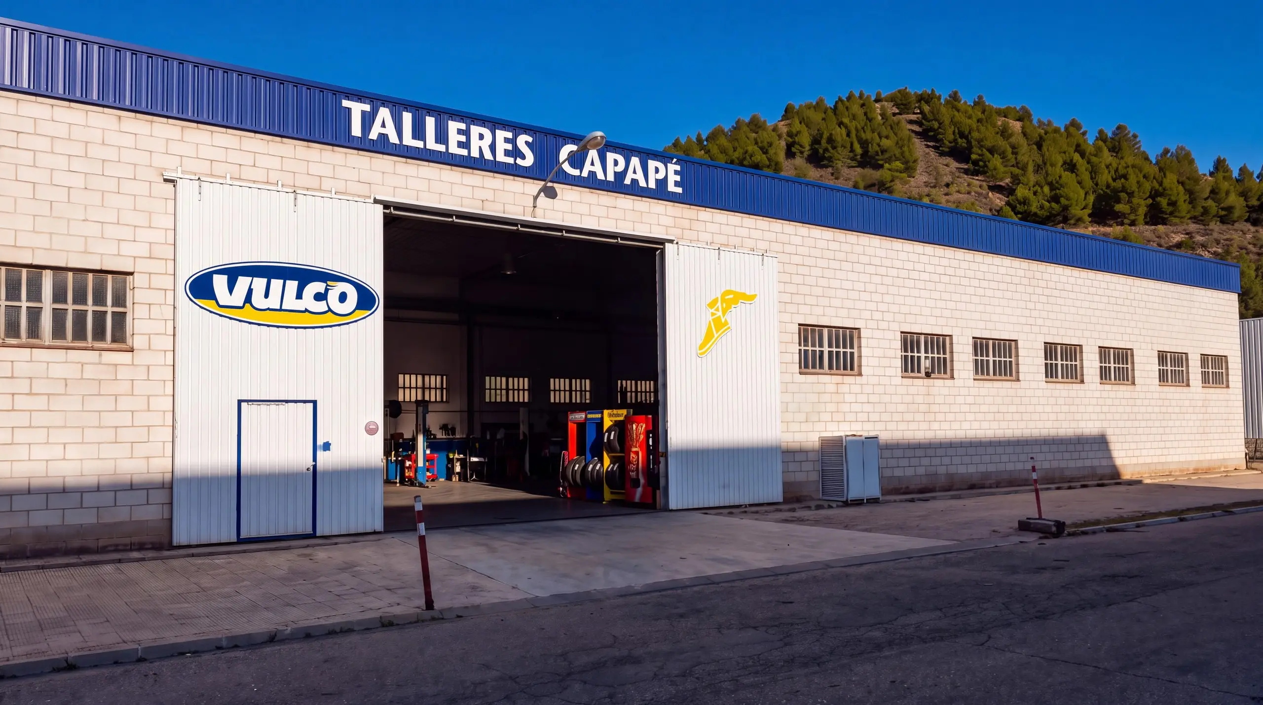 Fachada de Talleres Capapé en Illueca, con el rótulo sobre la franja azul